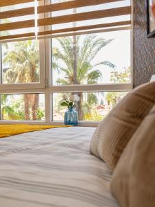 a bed in a bedroom with a large window at MaxiHomes Hadrian in Antalya