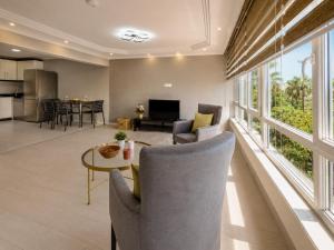 a living room with a table and chairs and a kitchen at MaxiHomes Hadrian in Antalya