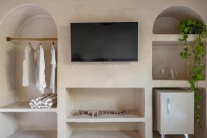 a living room with a tv on a wall at Casa do Amor Caraíva in Caraíva
