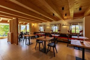 a restaurant with wooden tables and chairs in a room at Chalet Brento in Lundo +27 photos