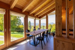 a dining room with a table and chairs in front of windows at Chalet Brento in Lundo
