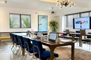 a conference room with a table and chairs with laptops at The Vagabond Hotel Miami in Miami
