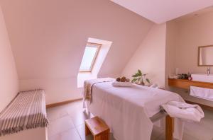 a white room with a bed and a sink at Wyndham Puerto Varas Pettra in Puerto Varas