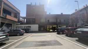 a parking lot with cars parked in front of a building at Suite Perlacasa in Vigevano