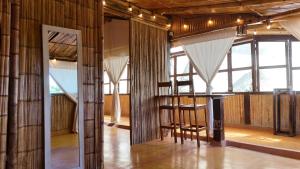 a room with wooden walls and a table and chairs at Eco Cabañas Bluekay in Mahahual