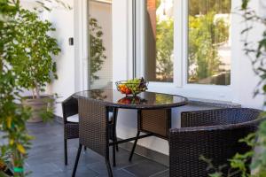 a glass table on a porch with two chairs at Studio apartman Lea in Baška +14 photos