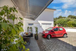 a small red car parked in front of a house at Studio apartman Lea in Baška