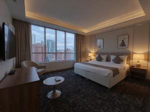 a hotel room with a bed and a large window at Hotel Grand Marina Near IGI Airport Delhi in Bichpuri