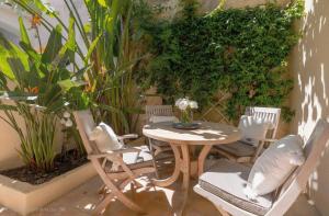a patio with a table and chairs and plants at Maison Magdeleine in Saint-Tropez