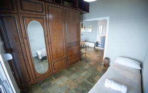 a room with a large wooden cabinet with a mirror at Blue Horizon Seafront Apartment in Agioi Theodoroi +13 photos