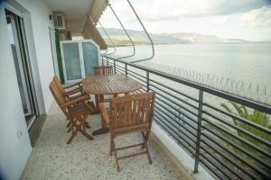 a balcony with a table and chairs and the water at Blue Horizon Seafront Apartment in Agioi Theodoroi