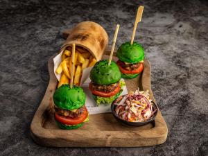 a wooden tray with three sandwiches and french fries at Mercure Nairobi Upper Hill in Nairobi