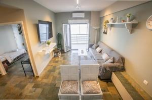 a living room with a couch and a table at Blue Horizon Seafront Apartment in Agioi Theodoroi