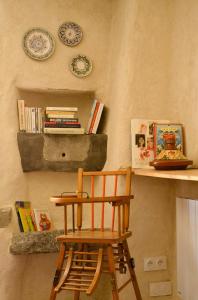 a wooden chair sitting next to a shelf with books at Gîte 'An Kay Ou' - L'Aiglette in Pontaix