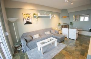 a living room with a couch and a table at Blue Horizon Seafront Apartment in Agioi Theodoroi