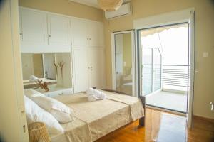 a bedroom with a bed and a sliding glass door at Blue Horizon Seafront Apartment in Agioi Theodoroi