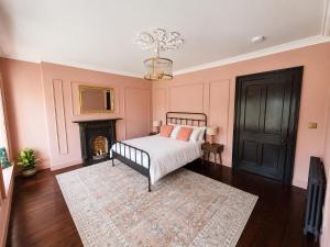 a pink bedroom with a bed and a fireplace at NO 60 Sligo in Sligo