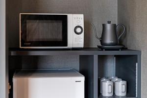 a microwave sitting on top of a shelf next to a refrigerator at 2F, 3F - Vacation STAY 20122v in Sumiyoshi