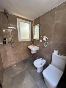 a bathroom with a toilet and a sink at Garden Beach House in Hamallë +14 photos