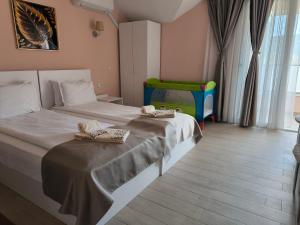 a bedroom with two beds and a baby crib at ALEKSANDAR - luxury stay private guest rooms in Gotse Delchev