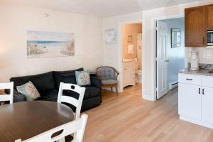 a living room with a black couch and a table at Unit 117 for Poolside Fun in Wells