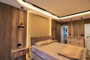 a bedroom with a bed with lights on the ceiling at AMD LUX apartman in Bijeljina +4 photos