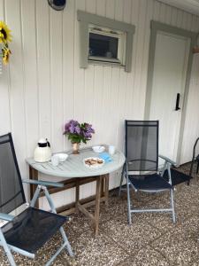 a table with two chairs and a table with flowers on it at Lugnt och centralt in Strömstad +6 photos