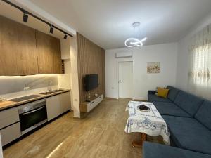 a living room with a blue couch and a kitchen at Garden Beach House in Hamallë