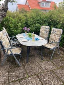 a table with chairs and flowers on a patio at Lugnt och centralt in Strömstad