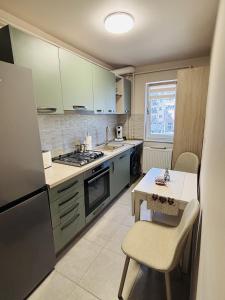 a kitchen with green cabinets and a table with a table at Apartament 29 in Orăştie