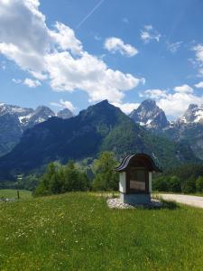 a sign in a field with mountains in the background at Ski & Sky Apartment in Hinterstoder