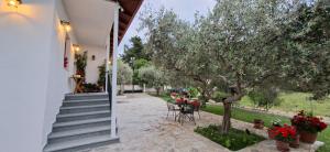 a house with stairs and a table and a tree at Family House in Platamonas