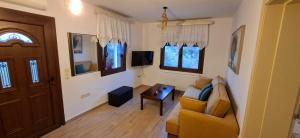 a living room with a couch and a tv at Family House in Platamonas