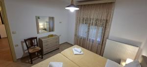 a bedroom with a bed and a dresser and a mirror at Family House in Platamonas