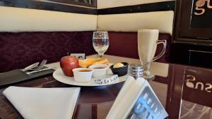 a table with a plate of food and glasses of wine at Grand City Hotel River View in Cairo