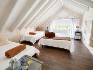a bedroom with two beds and a window at Hotel Casa Madero in Envigado