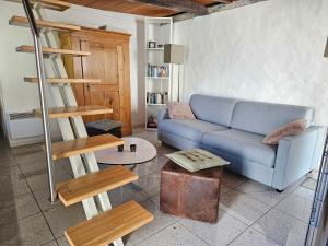 a living room with a blue couch and wooden furniture at Fienile in Avegno