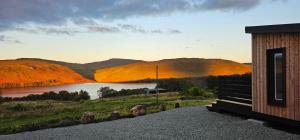 a cabin with a view of a lake and mountains at Croft Seven Cabins in Port na Long
