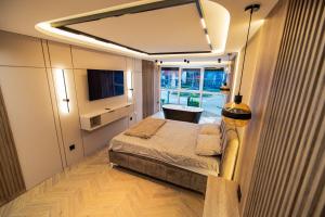 a bedroom with a bed and a television in it at AMD LUX apartman in Bijeljina