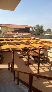 a row of wooden tables and benches on a building at Residencial Convênios- Hotelaria e Turismo LDA in Luanda