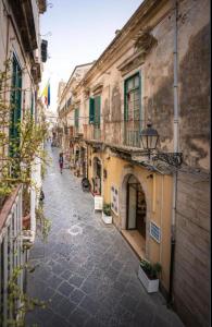 an alley with buildings and people walking down the street at Il Cortile Magico in Syracuse