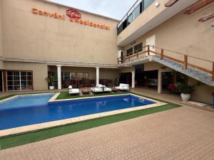 a hotel with a swimming pool in front of a building at Residencial Convênios- Hotelaria e Turismo LDA in Luanda
