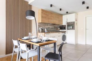 a dining room with a table and chairs and a kitchen at Apartament z Liskiem Szczyrk przy Żylicy SKI bus narty relaks i natura in Szczyrk