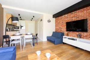 a living room with a blue couch and a brick wall at Apartament z Liskiem Szczyrk przy Żylicy SKI bus narty relaks i natura in Szczyrk