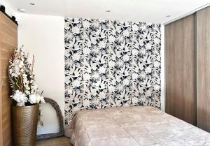 a bedroom with a bed and a black and white wallpaper at Maison plein pied in Sorgues