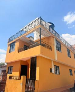 a yellow building with a balcony on top of it at Casa Amarilla SOL Apartamento Remodelado in Piedecuesta
