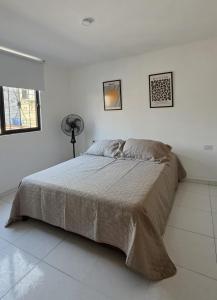 a bedroom with a large bed in a white room at Casa Amarilla SOL Apartamento Remodelado in Piedecuesta