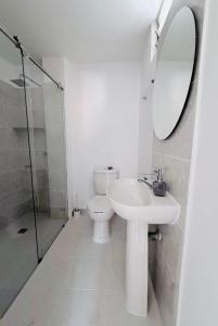 a bathroom with a toilet and a sink and a mirror at Casa Amarilla SOL Apartamento Remodelado in Piedecuesta +9 photos