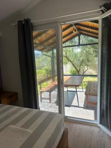 a bedroom with a bed and a sliding glass door at Garden Beach House in Hamallë