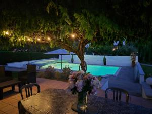 a table with a vase of flowers on a table with a pool at L'Esprit Cottage in La Tranclière +59 photos